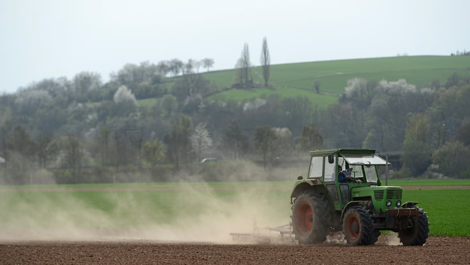 Ein Traktor fährt über ein Feld.