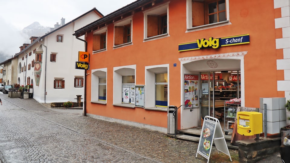 Volg-Laden in S-chanf an regnerischer Strasse.