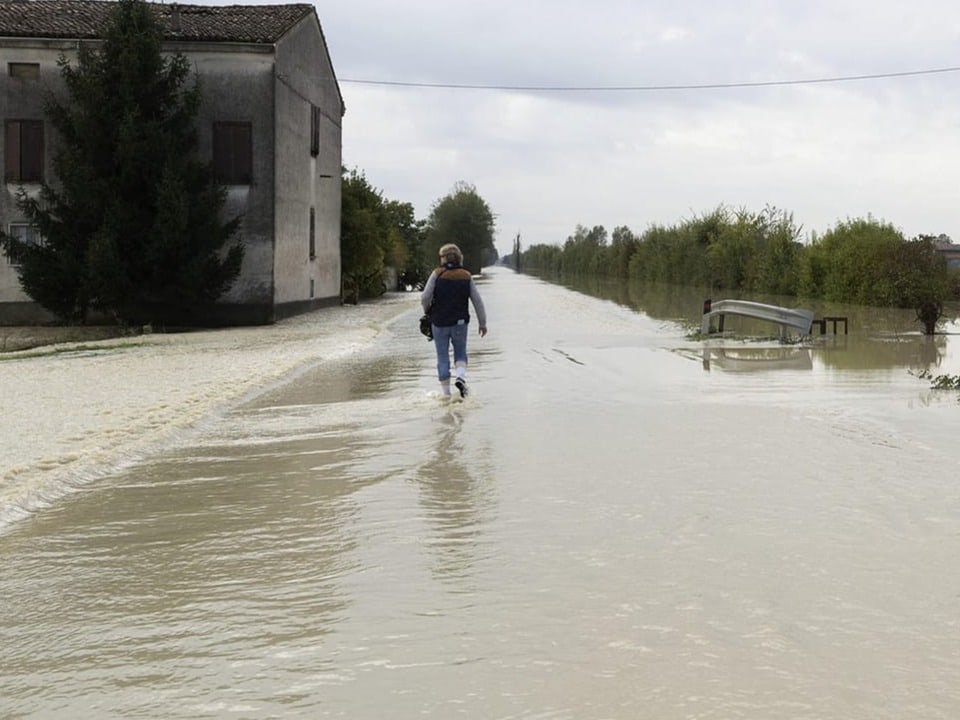 Ein Mann watet in Reggio knöcheltief durchs Wasser.