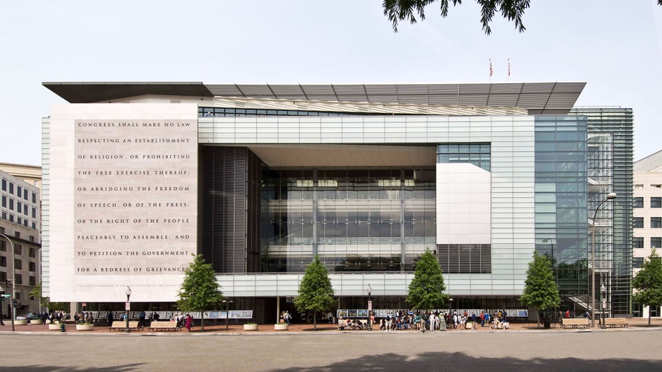 Das Gebäude des News-Museum: ein streng rechtwinkliges Gebäude. Auf der Fassade steht etwas.