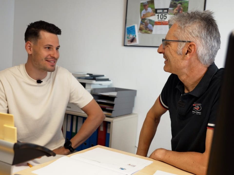 Livi und sein Vater besprechen das Geschäft zusammen am Bürotisch.