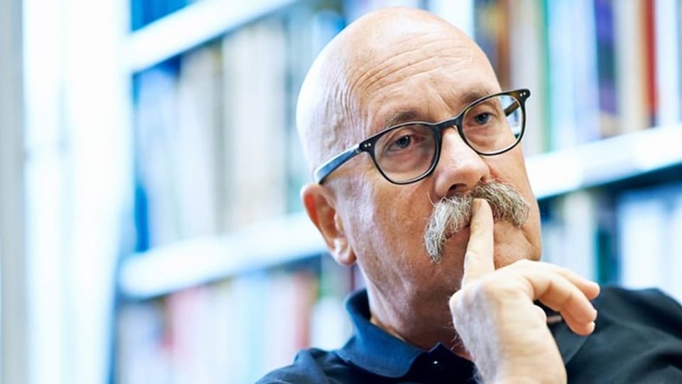 Porträt Rolf Weingartner, Mann mit Glatze und Brille und Schnauz.