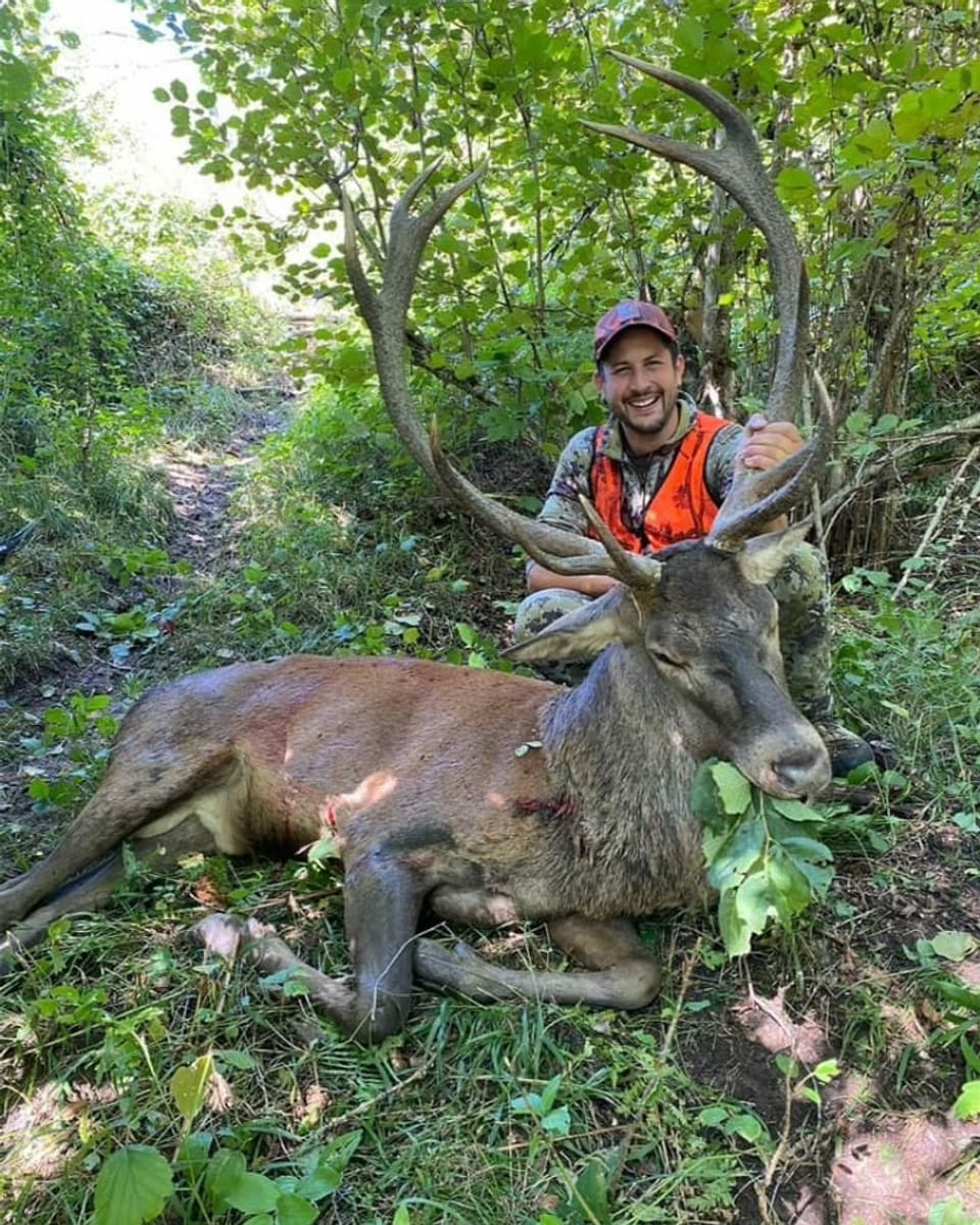 Jäger mit Hirsch im Wald.