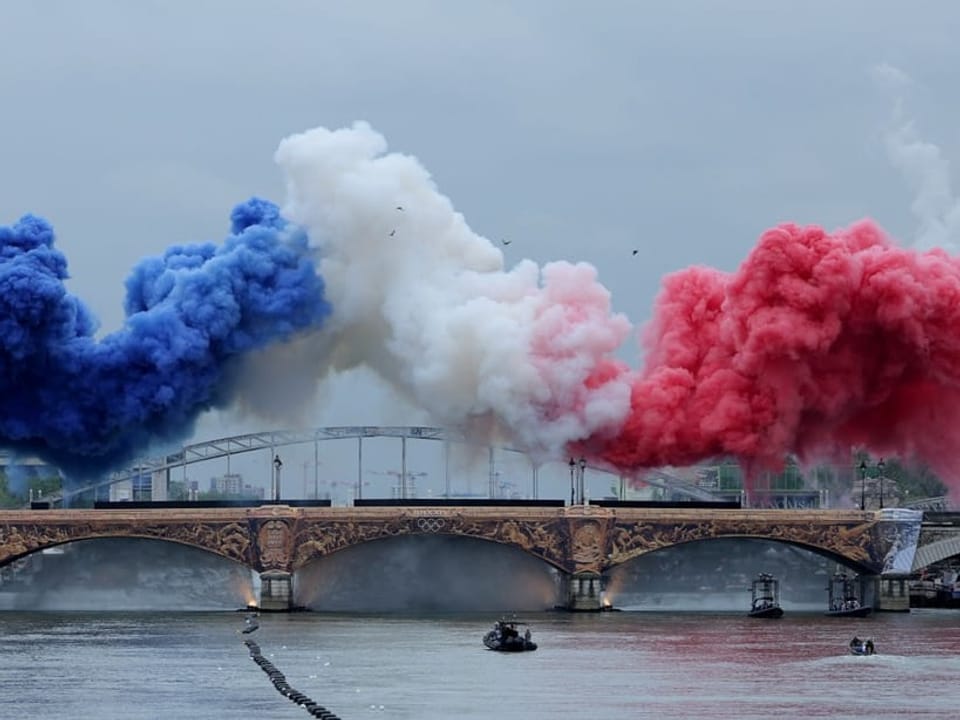 Rauchwolken in den Farben der französischen Nationalflaggen über der Brücke.