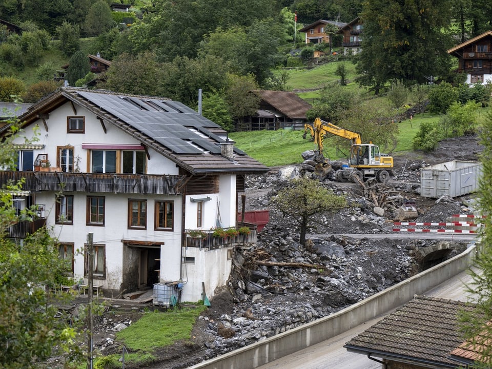 Bauarbeiten bei einem Haus in hügeliger Landschaft.