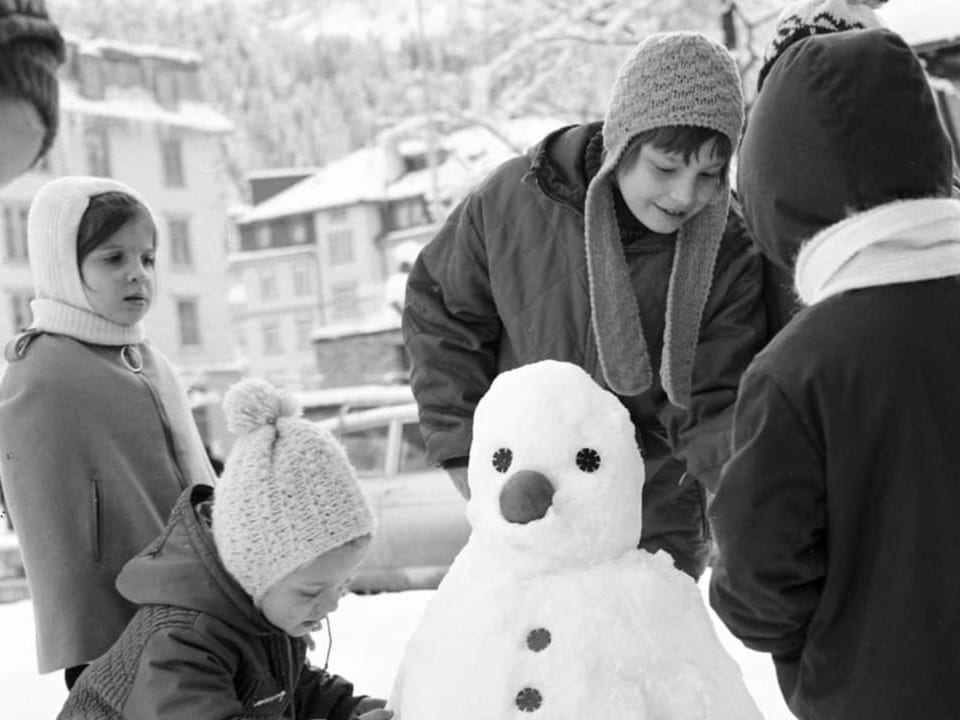 Kinder bauen einen Schneemann 1970