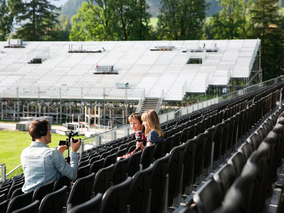 Zwei Kinder sitzen auf einer Tribüne.