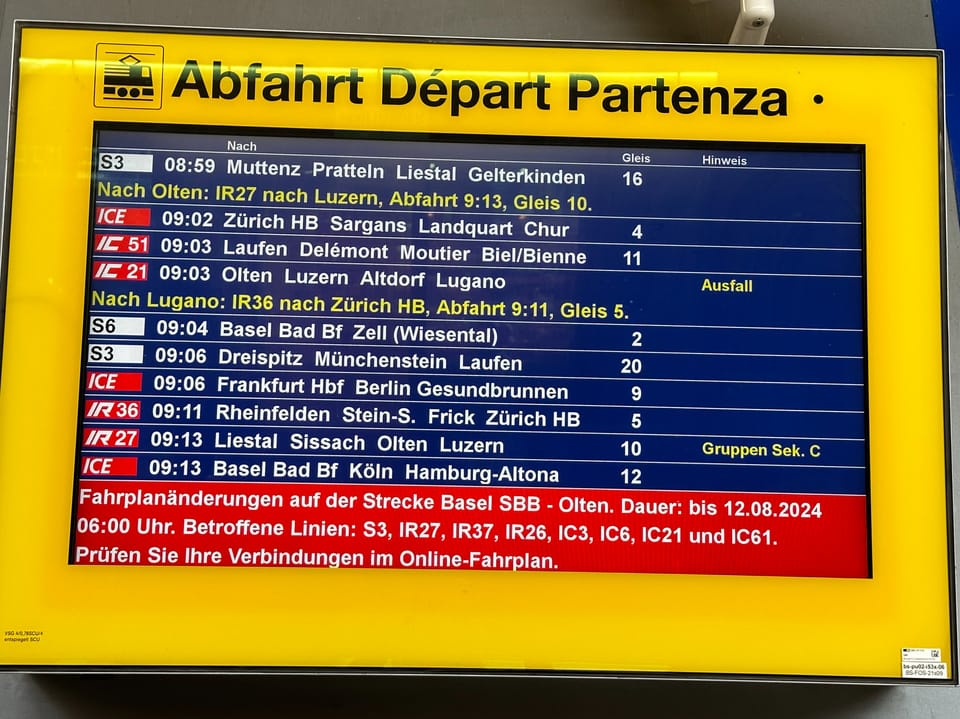 Farbiger Bildschirm am Bahnhof mit Informationen.