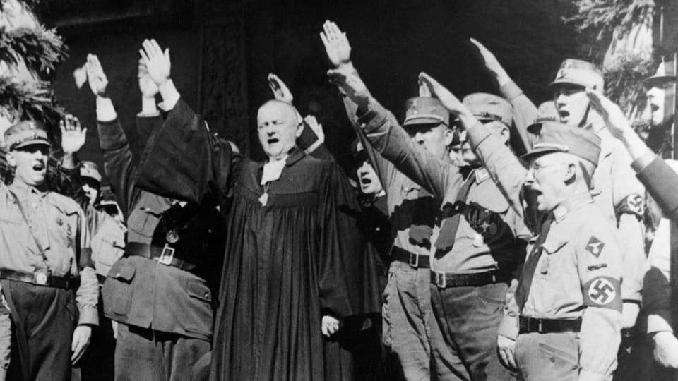 Ein Bischof inmitten von uniformierten Nazis. Alle machen den Hitlergruss