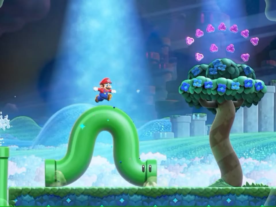Szene aus dem Spiel. Super Mario springt auf eine ligende Röhre mit Augen, die sich krümmt wie eine Raupe.