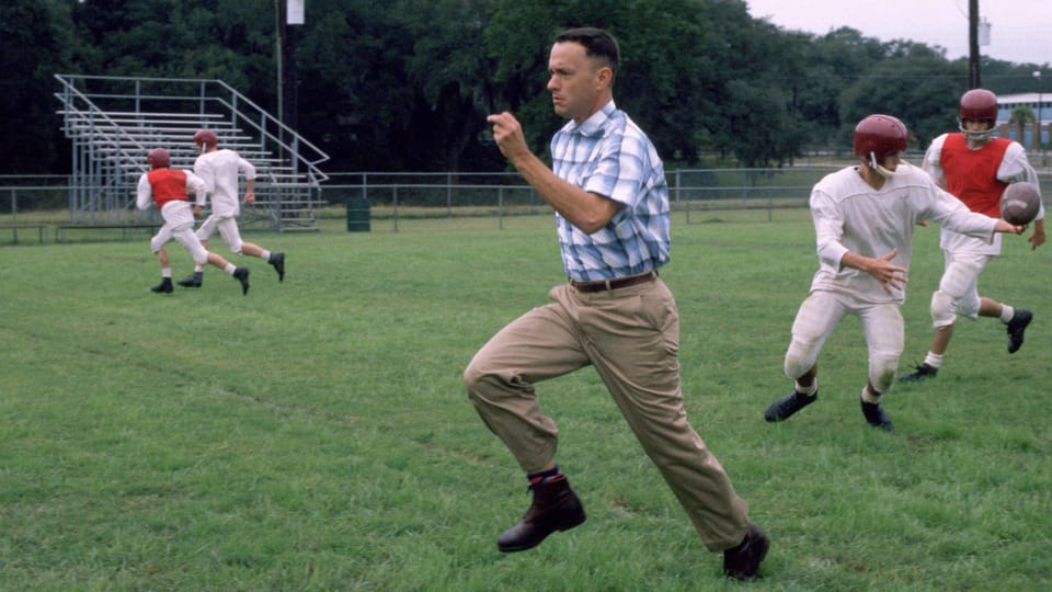 Mann im Karo-Hemd rennt auf dem Baseball-Platz.