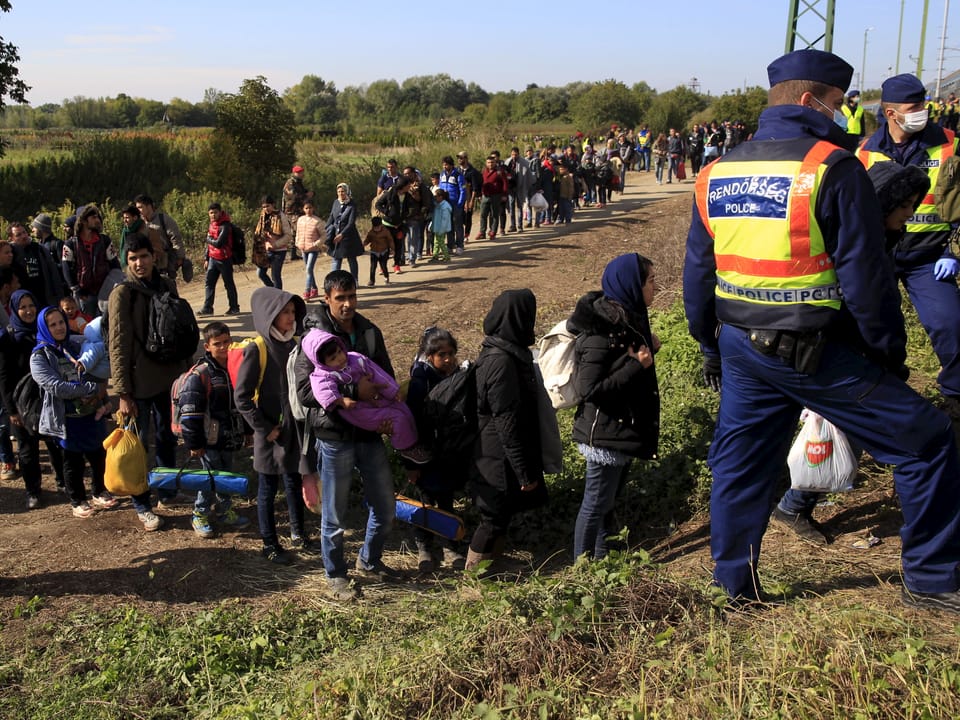 Menschen stehen auf einem Feldweg Schlange