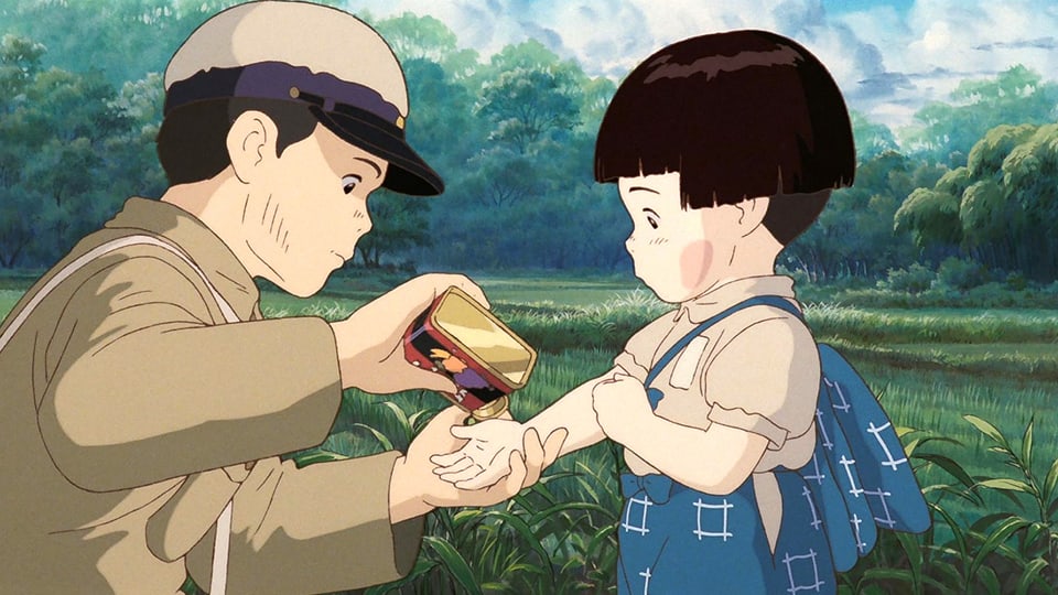 Ein junge gibt seiner kleinen Schwester ein Bonbon auf die Hand.