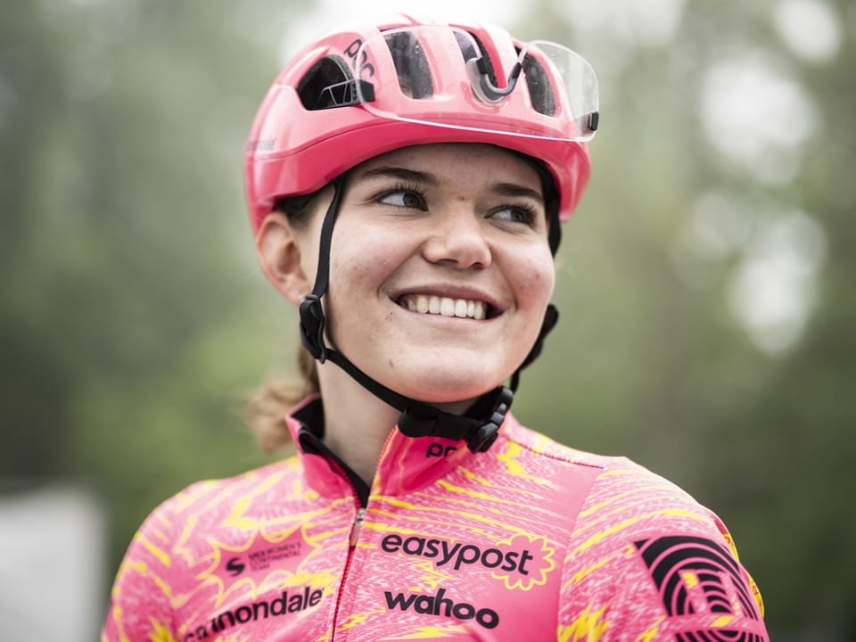 Radfahrerin in pinker Ausrüstung lächelnd