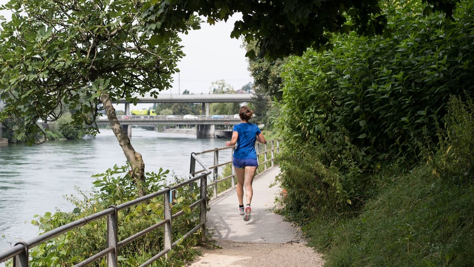 Eine Joggerin auf einem Laufweg entlang der Limmat.