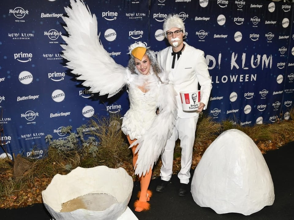 Zwei Personen in Vogel- und Kolonel-Kostümen bei Halloween-Event.