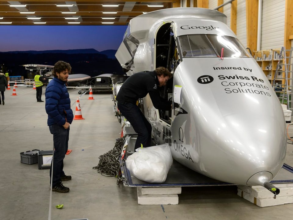 Mitarbeiter von Solar Impulse bereiten das Cockpit des Solarflugzeugs für den Transport vor