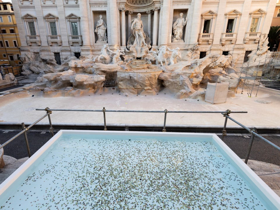 Trevi-Brunnen mit Wasserbecken voller Münzen und skulpturaler Fassade.