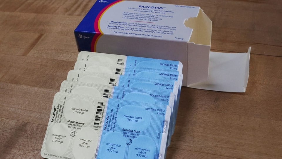Medikamentenschachtel mit Paxlovid-Tabletten.