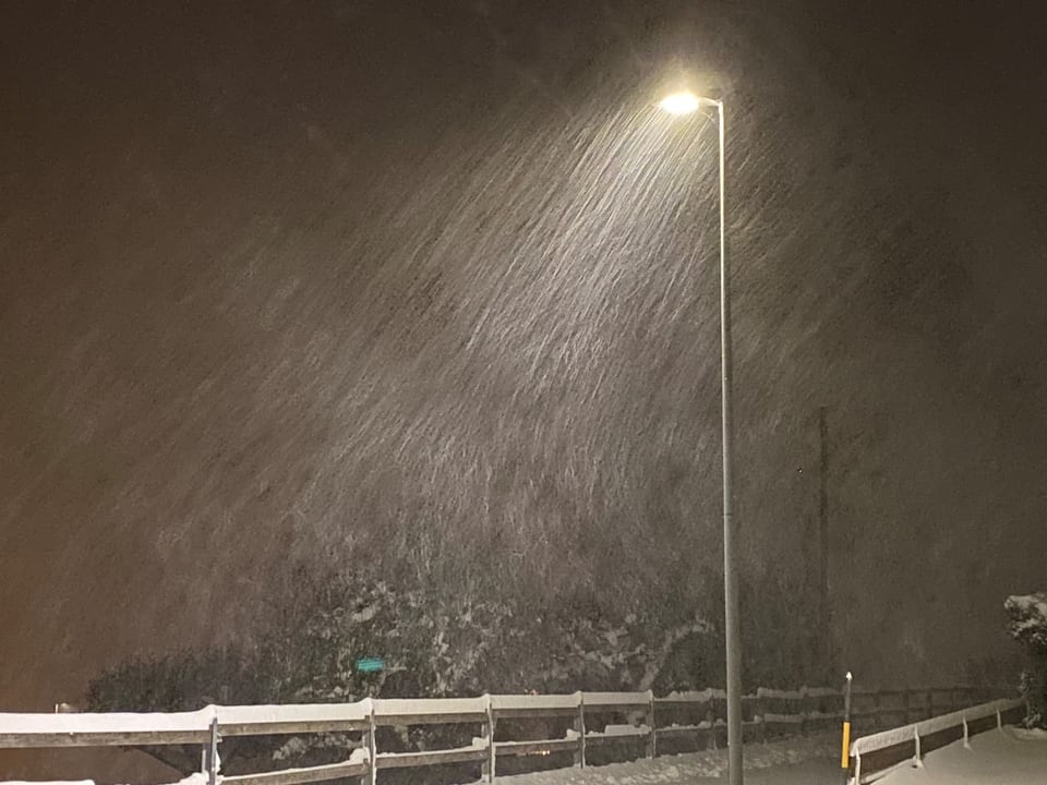 Strassenlaterne bei starkem Schneefall in der Nacht.