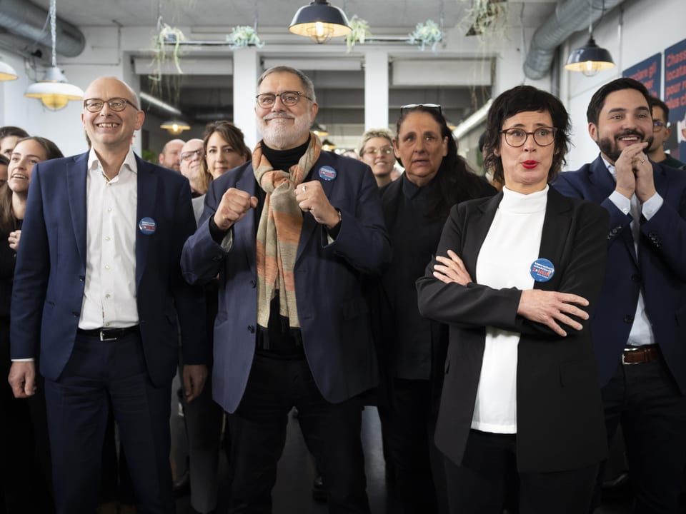 Gruppe von Menschen lächelt und applaudiert in einem Raum.