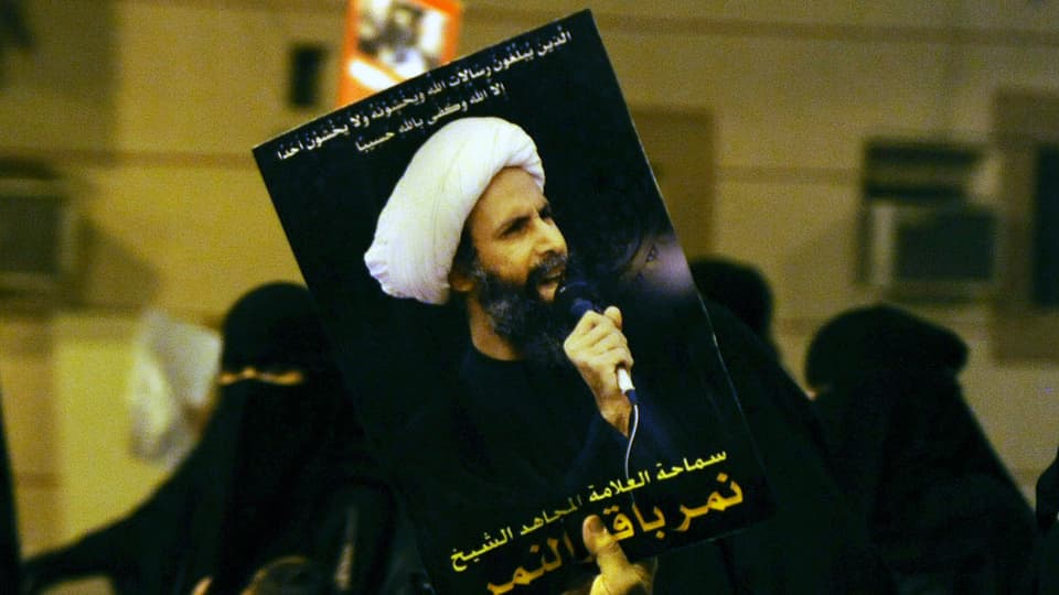 Eine Demonstrantin trägt ein Bild von Nimr Baker al Nimr (2012) 