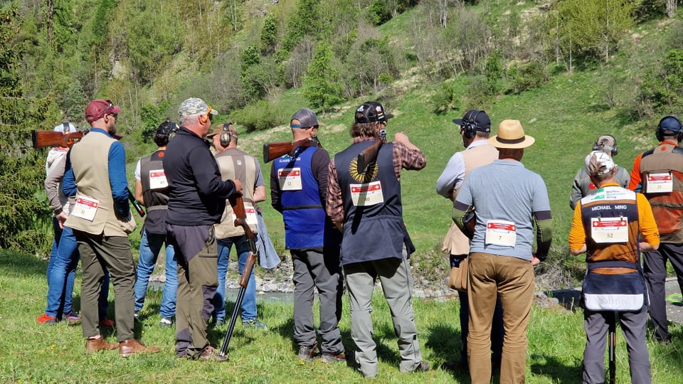 Eine Gruppe Schützen stehen mit dem Rücken zur Kamera, alla mit Startnummern auf dem Rücken.