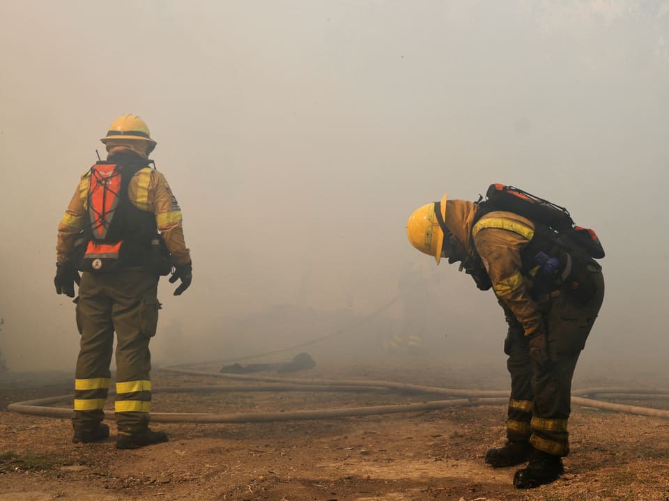 Zwei Feuerwehrleute in Rauch.