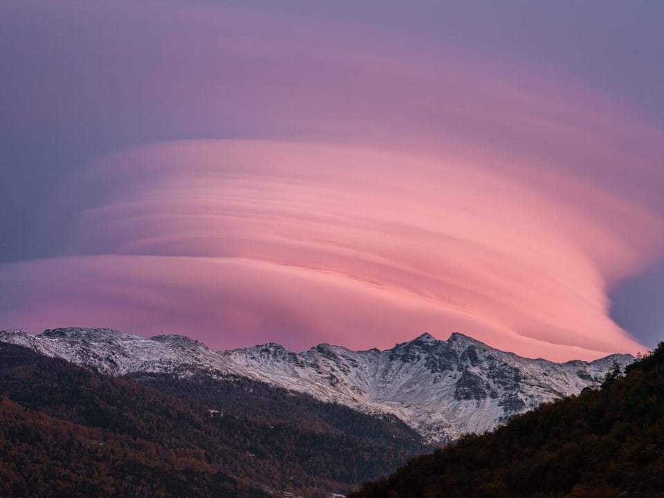 Berglandschaft bei Sonnenuntergang mit rosa Wolken.