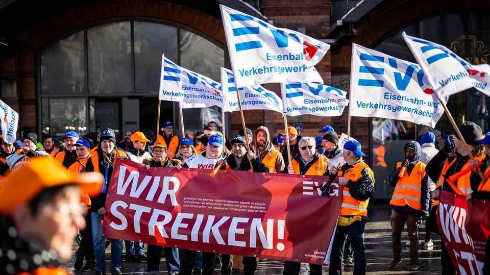 Demonstranten der EVG stehen mit Plakaten vor dem Hauptbahnhof Bremen