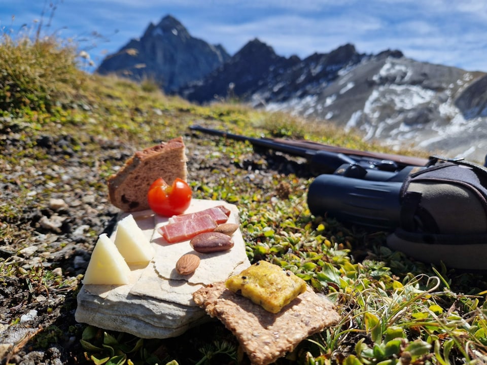 Ein Stein mit Käse, Flesch, einer Cherrytomate und Nüssen