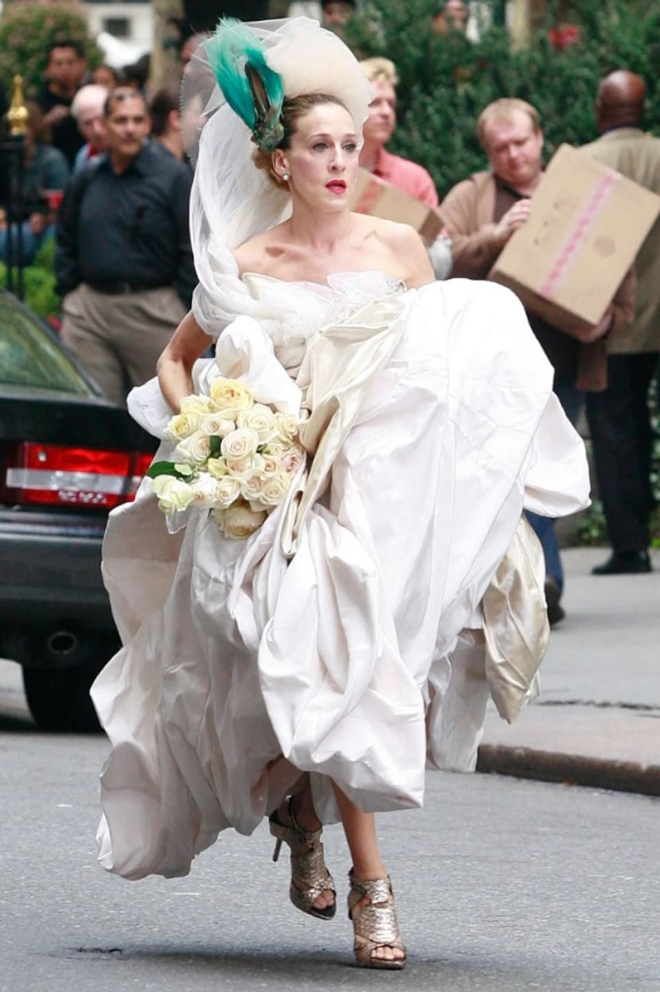 Carrie Bradshow rennt in High-Heels über die Strasse. Sie trägt ein Hochzeitskleid.