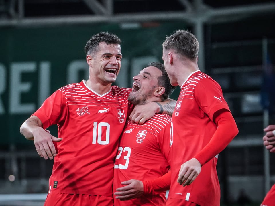 Drei Fussballspieler der Schweizer Nationalmannschaft feiern ein Tor.
