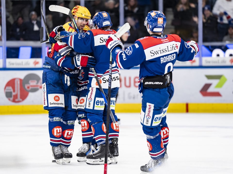 Eishockeyspieler umarmen sich auf dem Spielfeld.