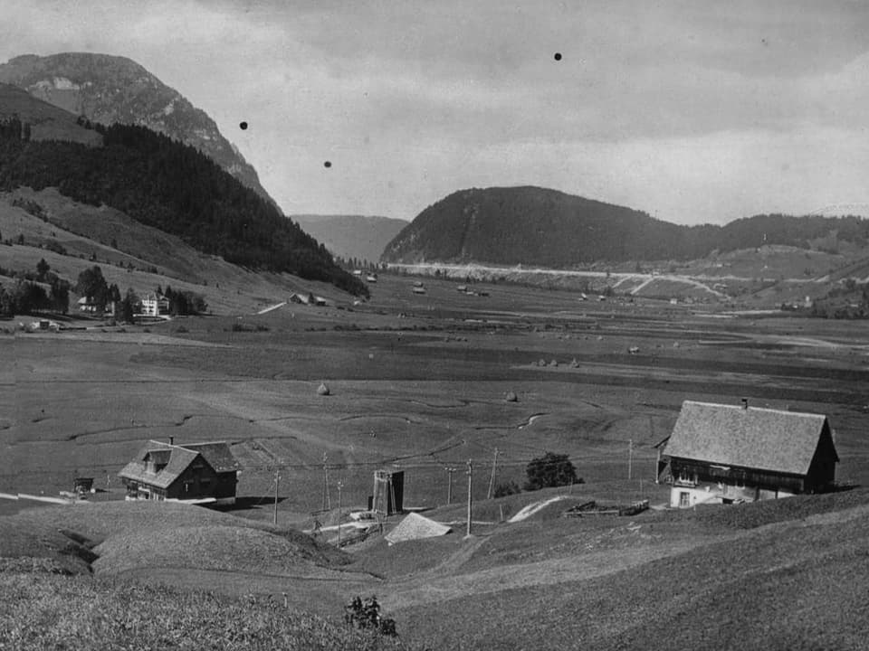 Blick auf eine ländliche Landschaft mit Bergen und Bauernhäusern.