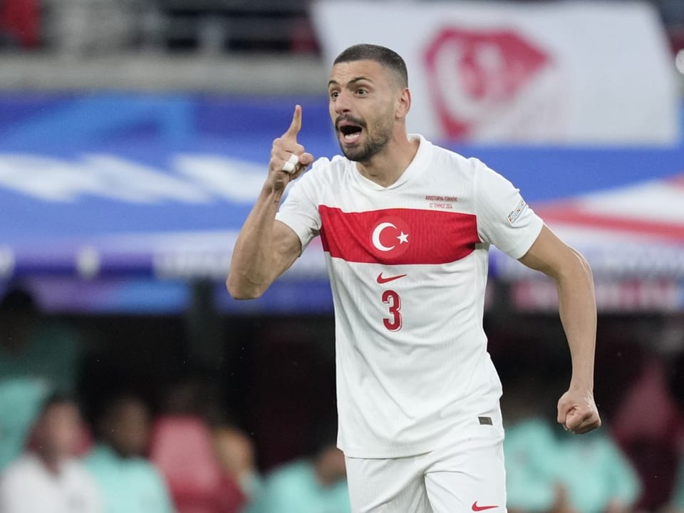 Türkischer Fussballspieler im weissen Trikot mit rotem Streifen.