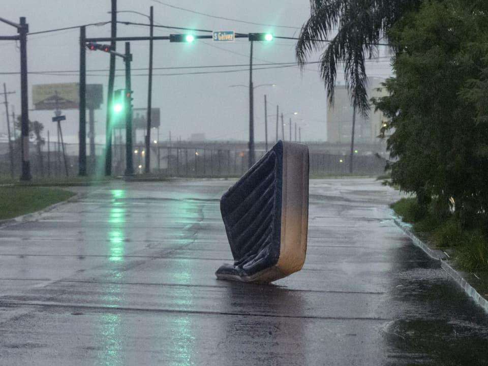 Aufgeblasene Matratze steht aufrecht auf nasser Strasse bei Regen.