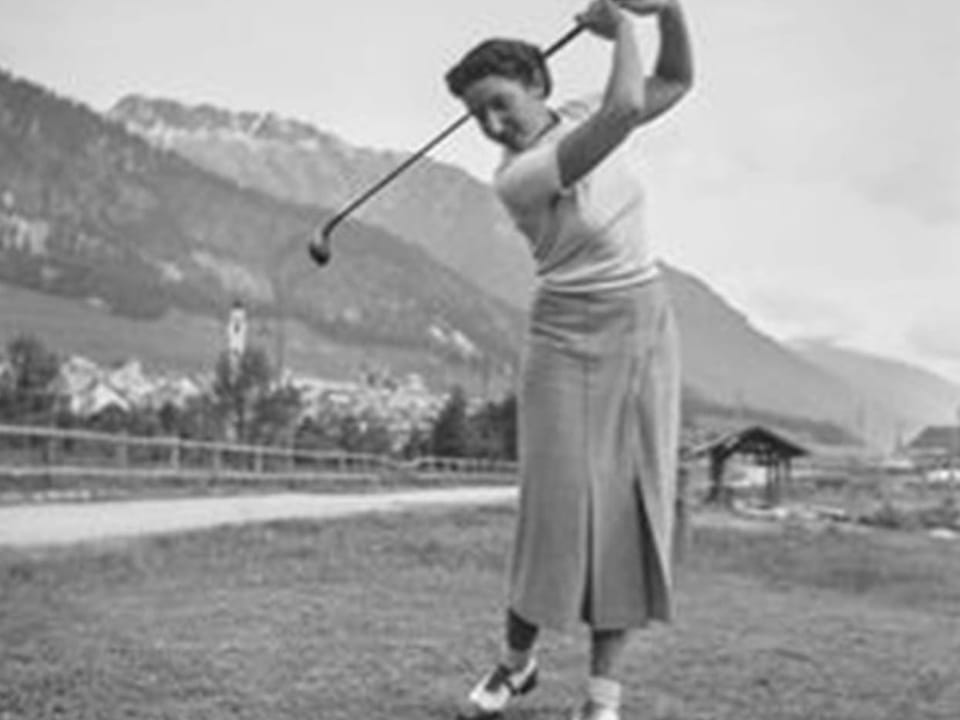 Frau schwingt den Golfschläger auf dem Golfplatz Samedan.