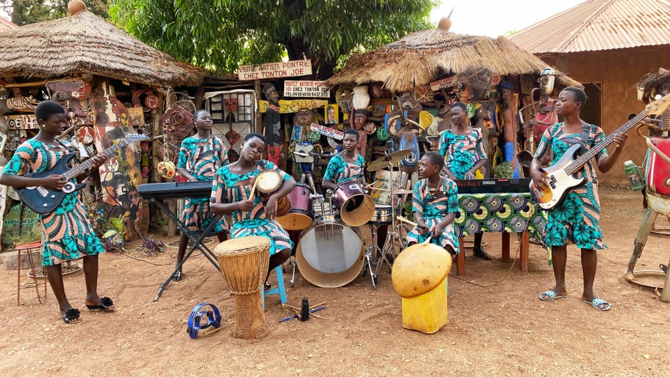 sieben junge schwarze Mädchen musizieren auf ihren Instrumenten