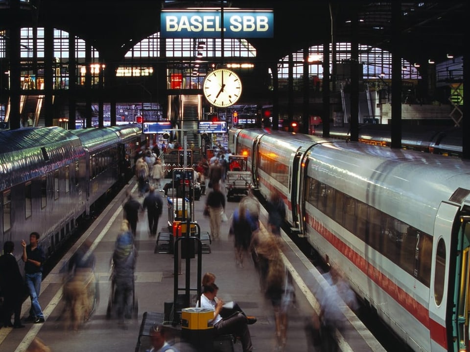 Menschen und Züge am Bahnhof Basel SBB.