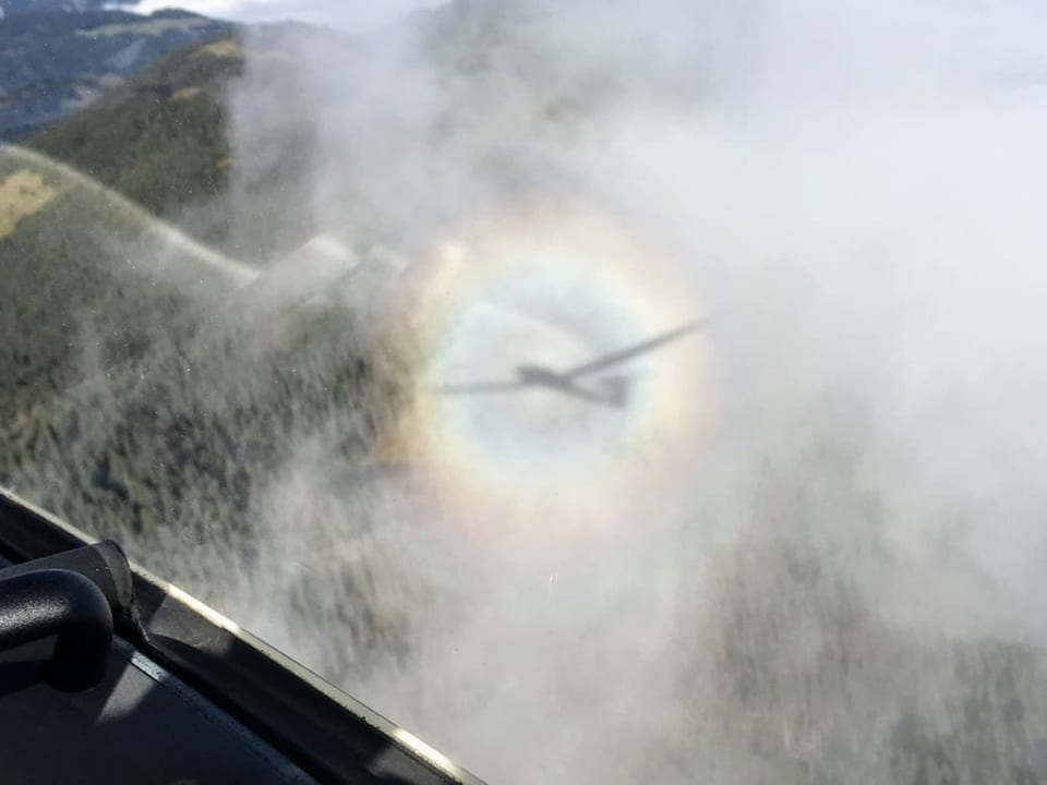 Flugzeugschatten und Regenbogen im Nebel aus Cockpit.