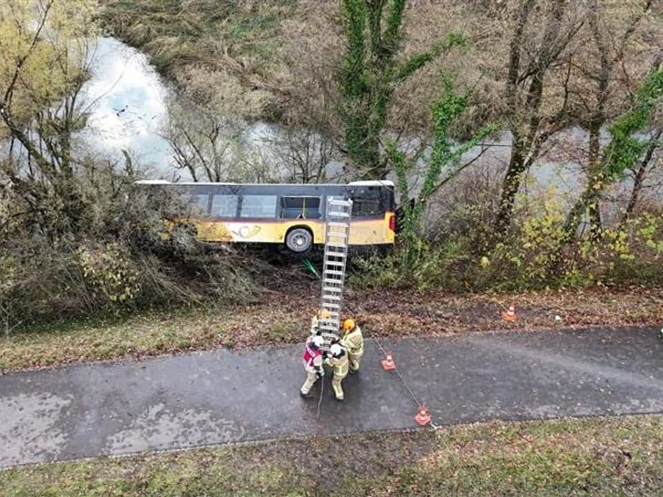 Ein Postauto liegt seitlich neben der Strasse