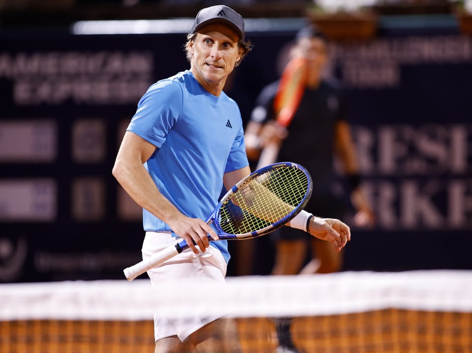 Tennisspieler mit Schläger auf dem Platz.