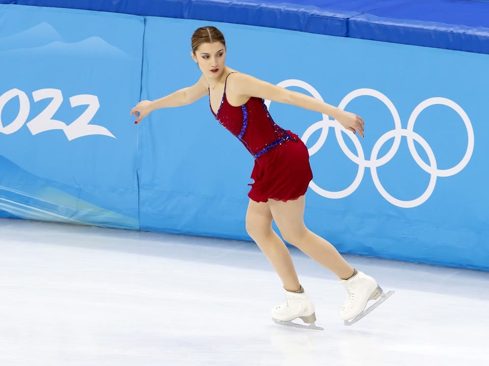 Eiskunstläuferin in rotem Kleid bei den Olympischen Spielen.