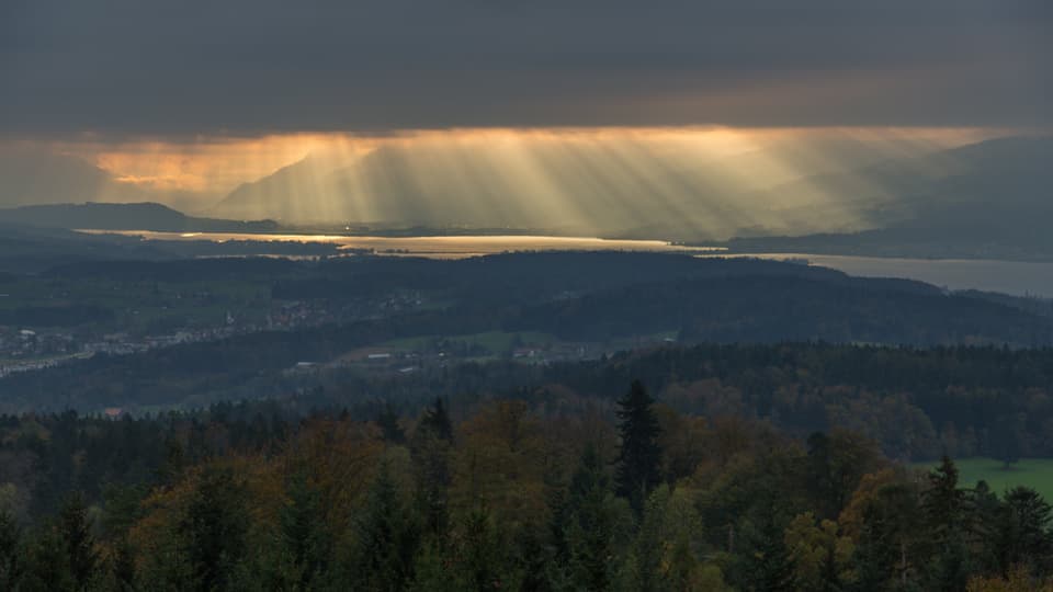 Sonnenstrahlen kämpfen sich durch eine Hochnebeldecke.