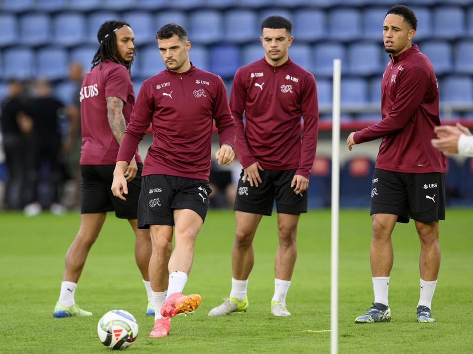 Vier Fussballspieler beim Training auf dem Spielfeld.