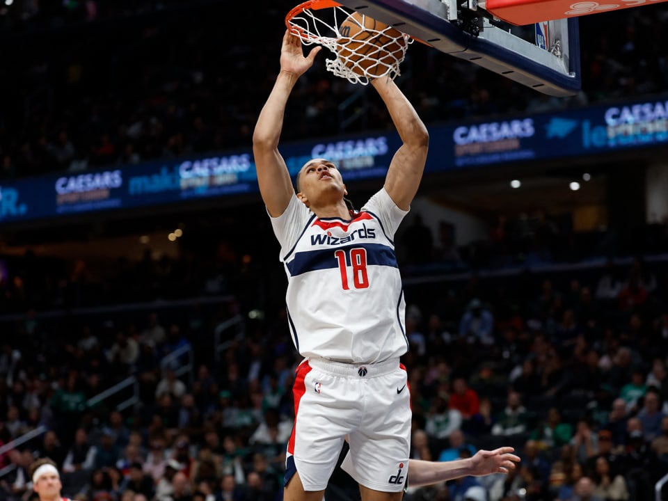 Basketballspieler der Wizards beim Dunk in einer Arena.