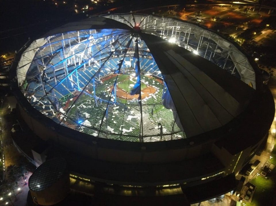 Nachtsicht eines beleuchteten Stadions mit offenem Dach.