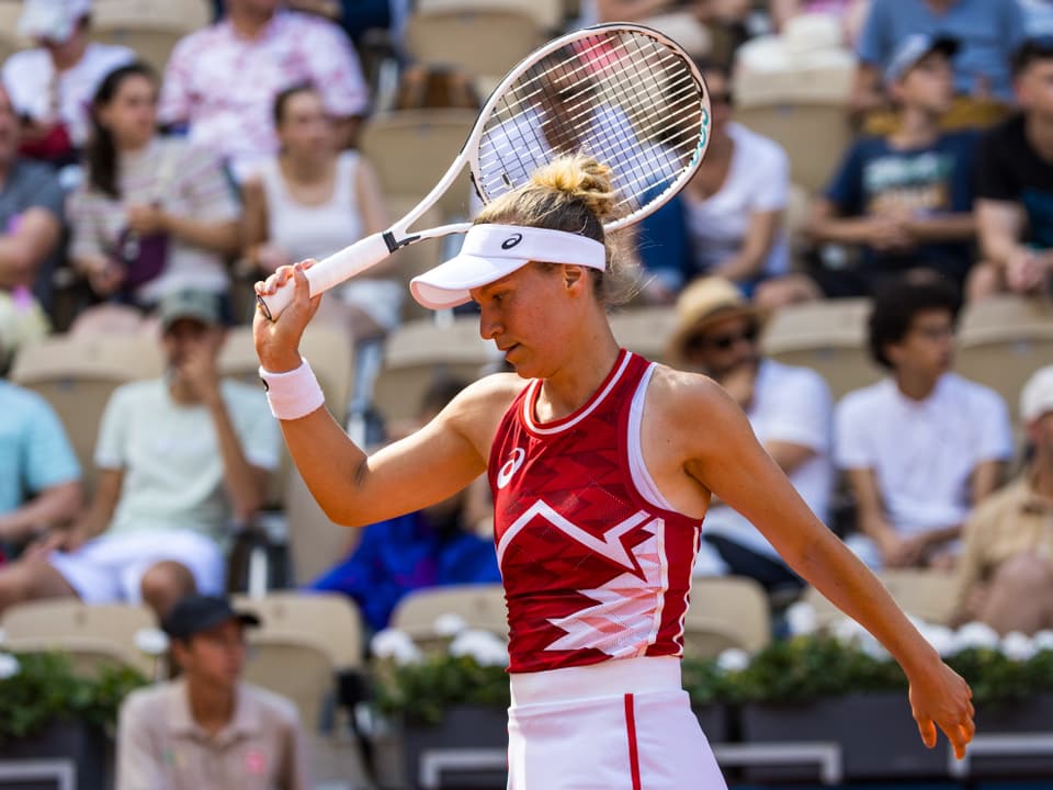 Tennisspielerin mit Schläger vor Publikum.