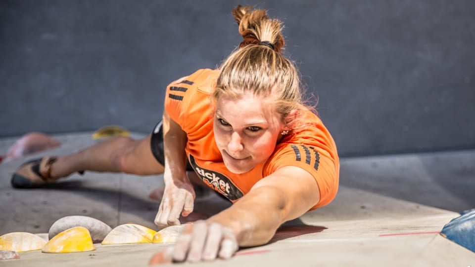 Junge Frau an einer Kletterwand, von oben fotografiert.